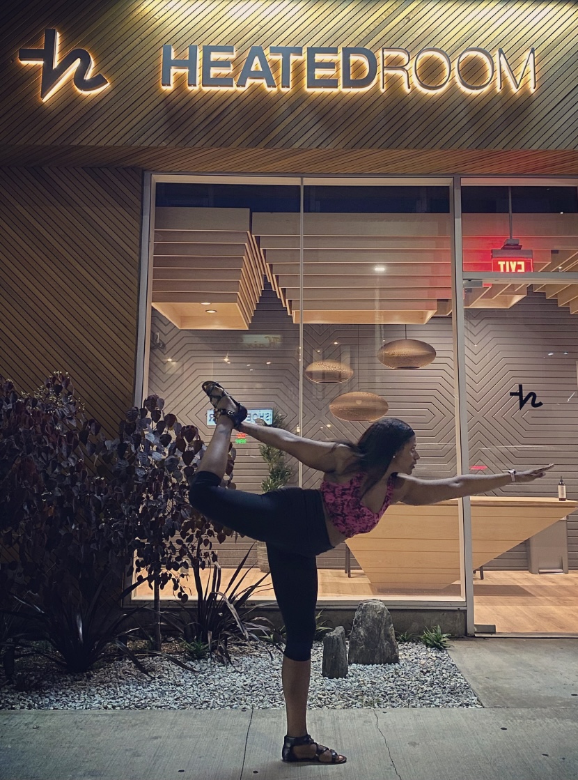 An image of a woman doing a yoga pose outside of Heated Room.