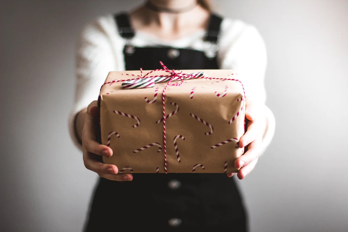An image of someone holding a wrapped holiday gift.