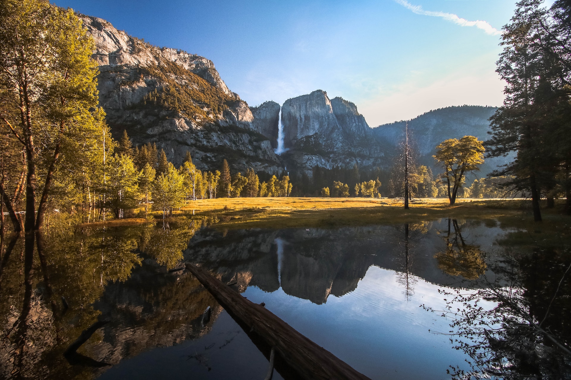 An image of Yosemite National Park. You can see the lake, with mountains, trees, and a waterfall in the reflection.