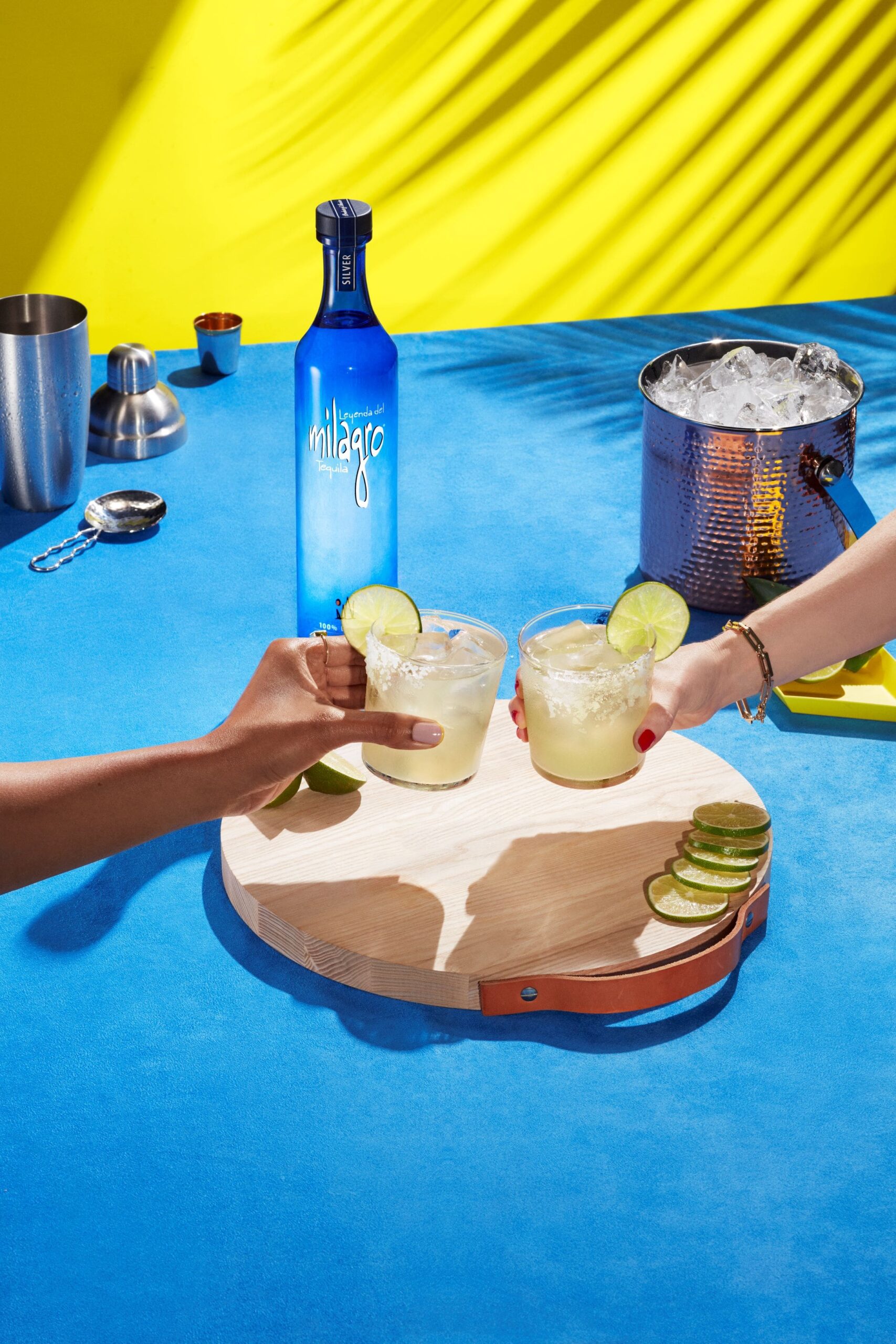 An image of a bottle of Milagro tequila and two margaritas