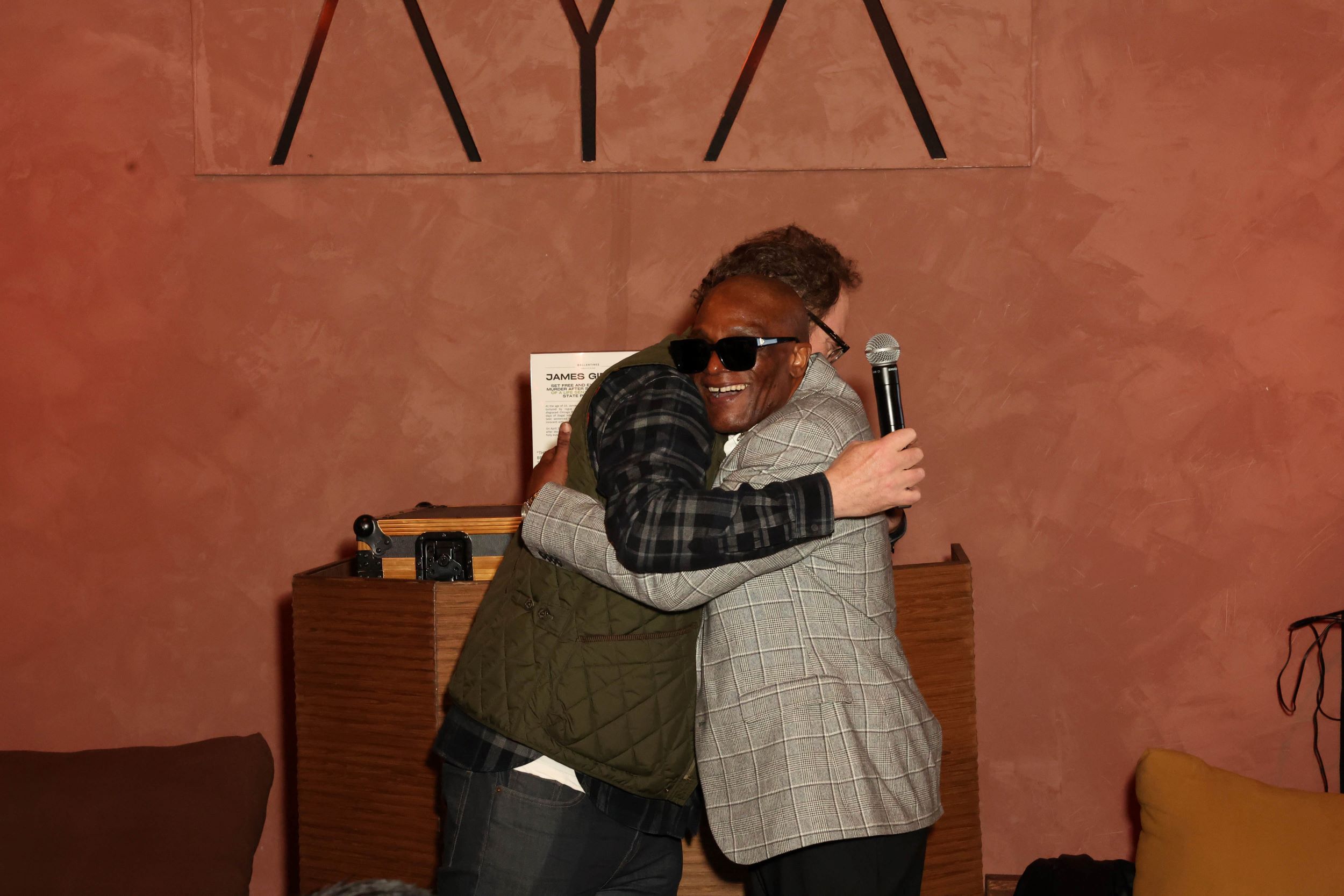 An image of Rainn Wilson and James Gibson embracing.