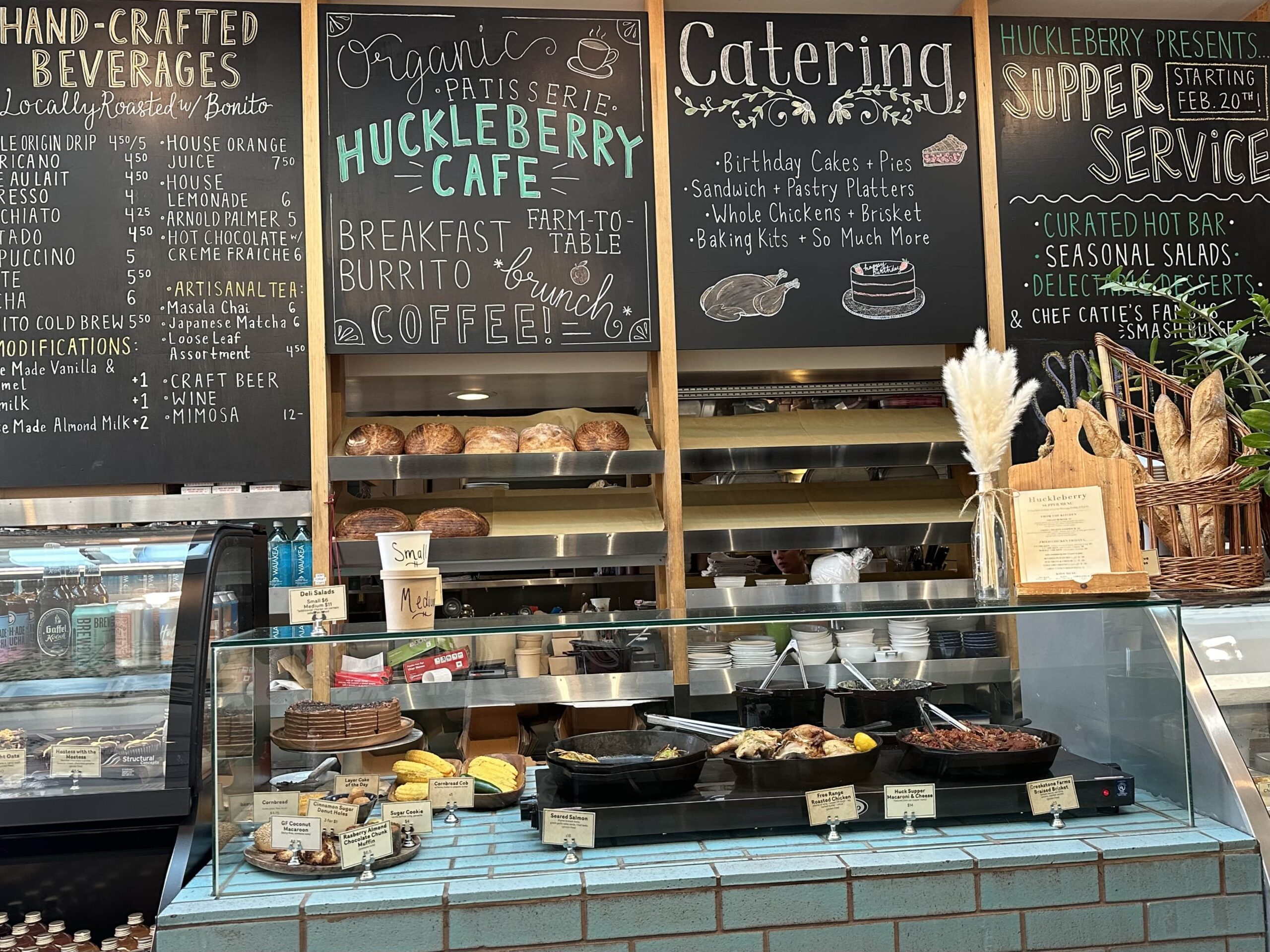 An image of the counter at Huckleberry with the signs and supper items in a case.