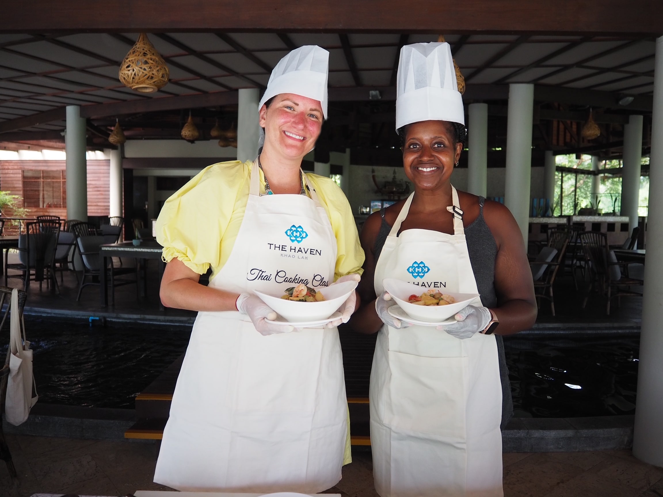 An image of Ariel and her friend posing with their dishes made during their Thai cooking class.