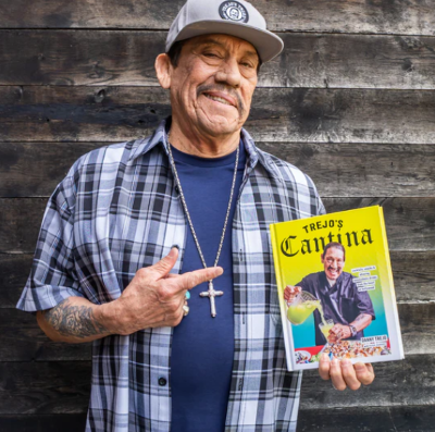 An image of Danny Trejo holding his new cookbook Trejo’s Cantina: Cocktails, Snacks & Amazing Non-Alcoholic Drinks from the Heart of Hollywood.
