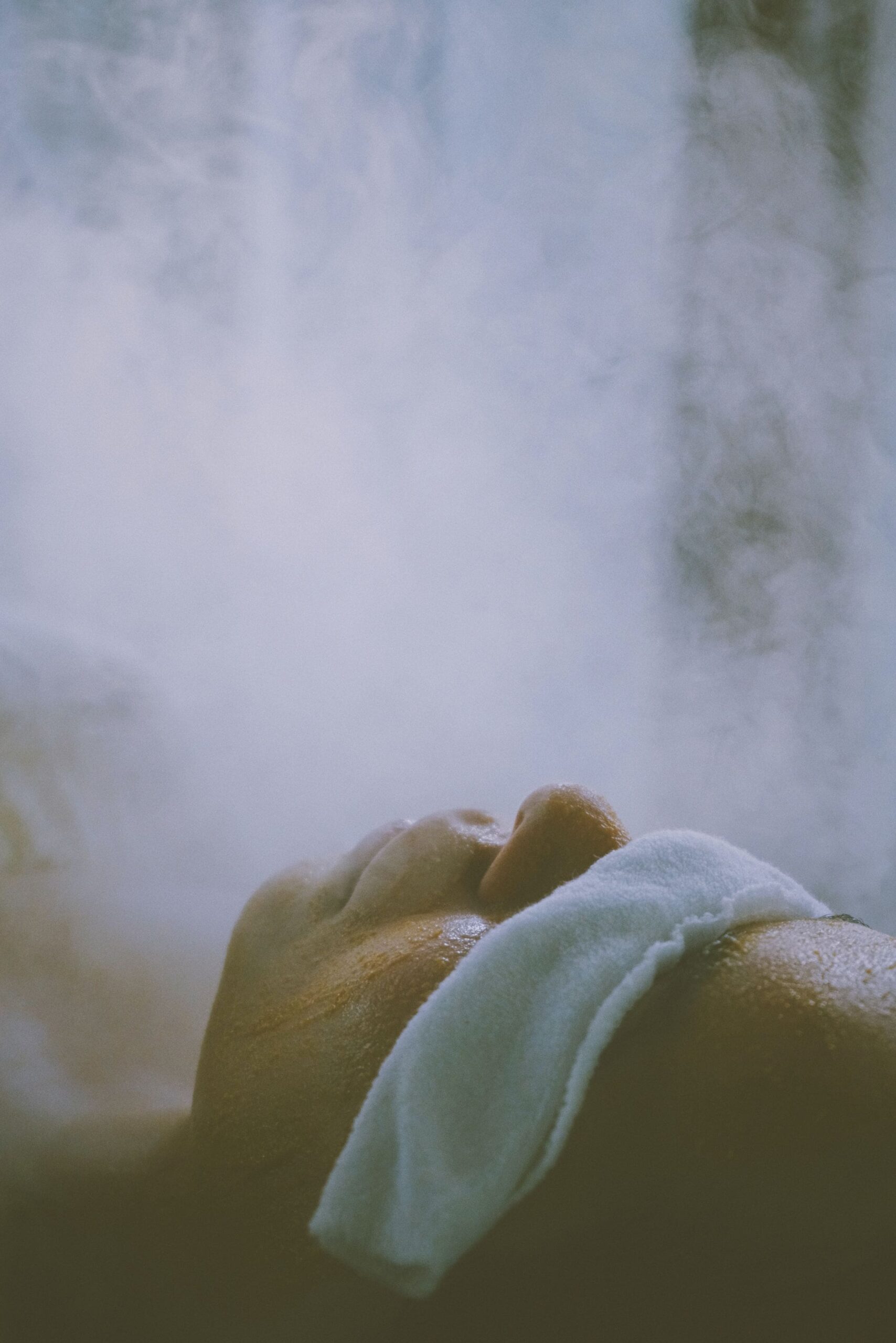 An image of a woman getting her face steamed during a facial.