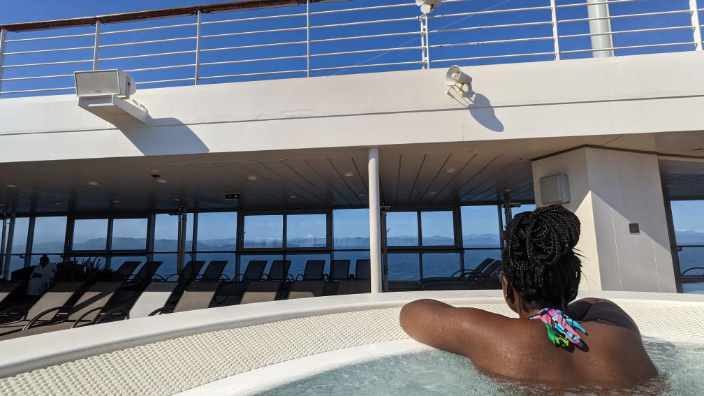 An image of Ariel in the deck hot tub. You can see land out the windows off the deck. 