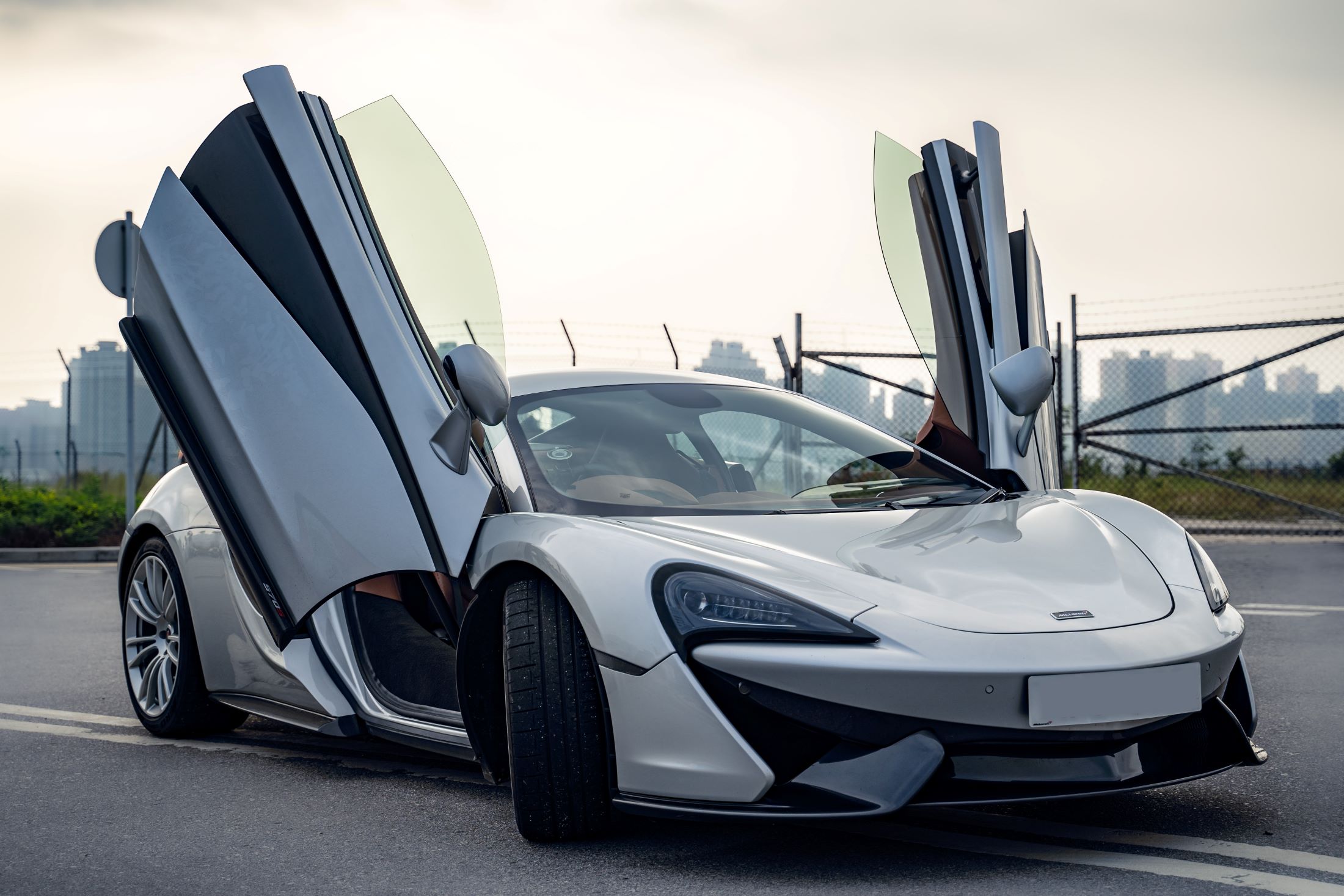 An image of a White Mclaren with the doors up.