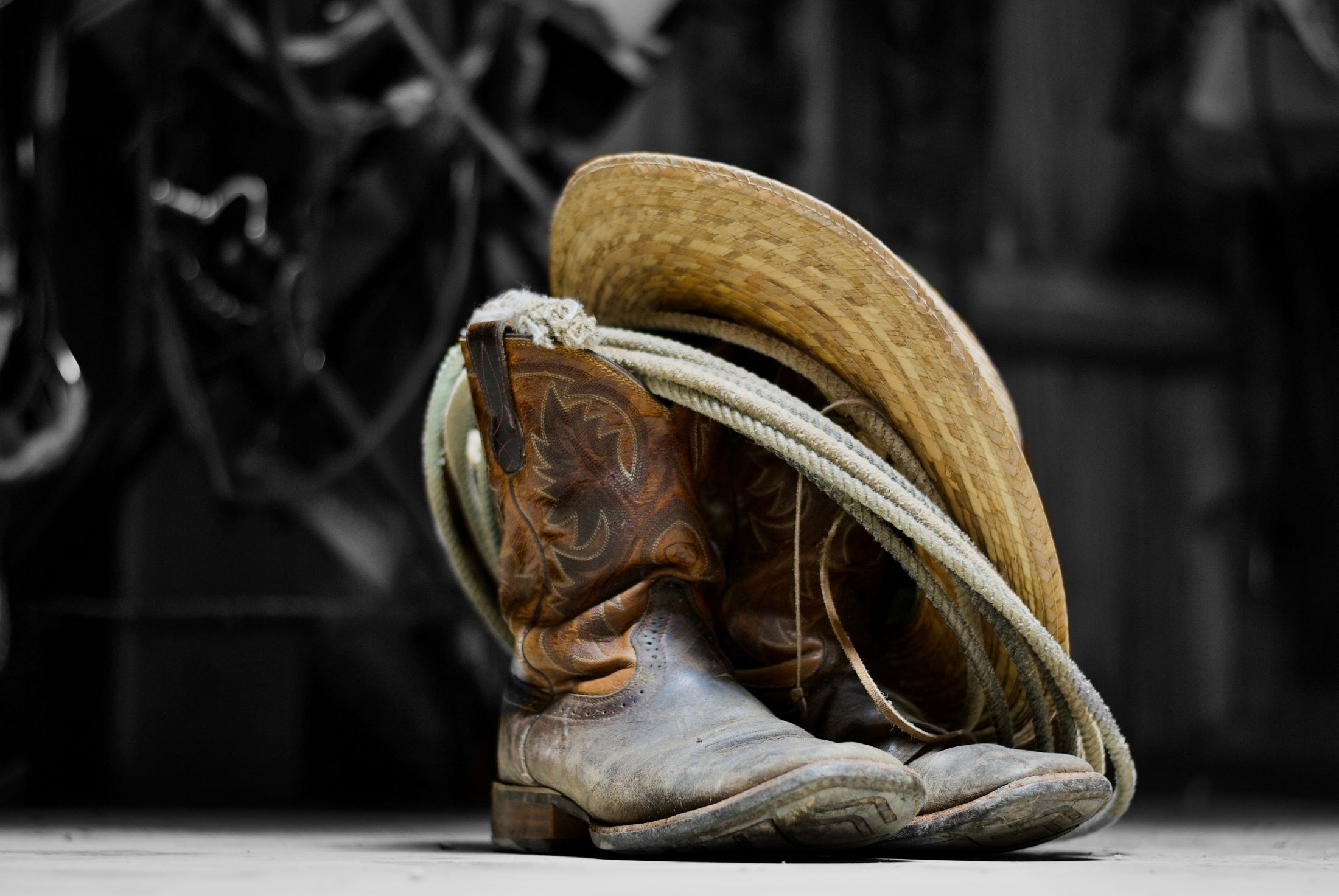 An image of cowboy boots, a vowboy hat, and a rope.