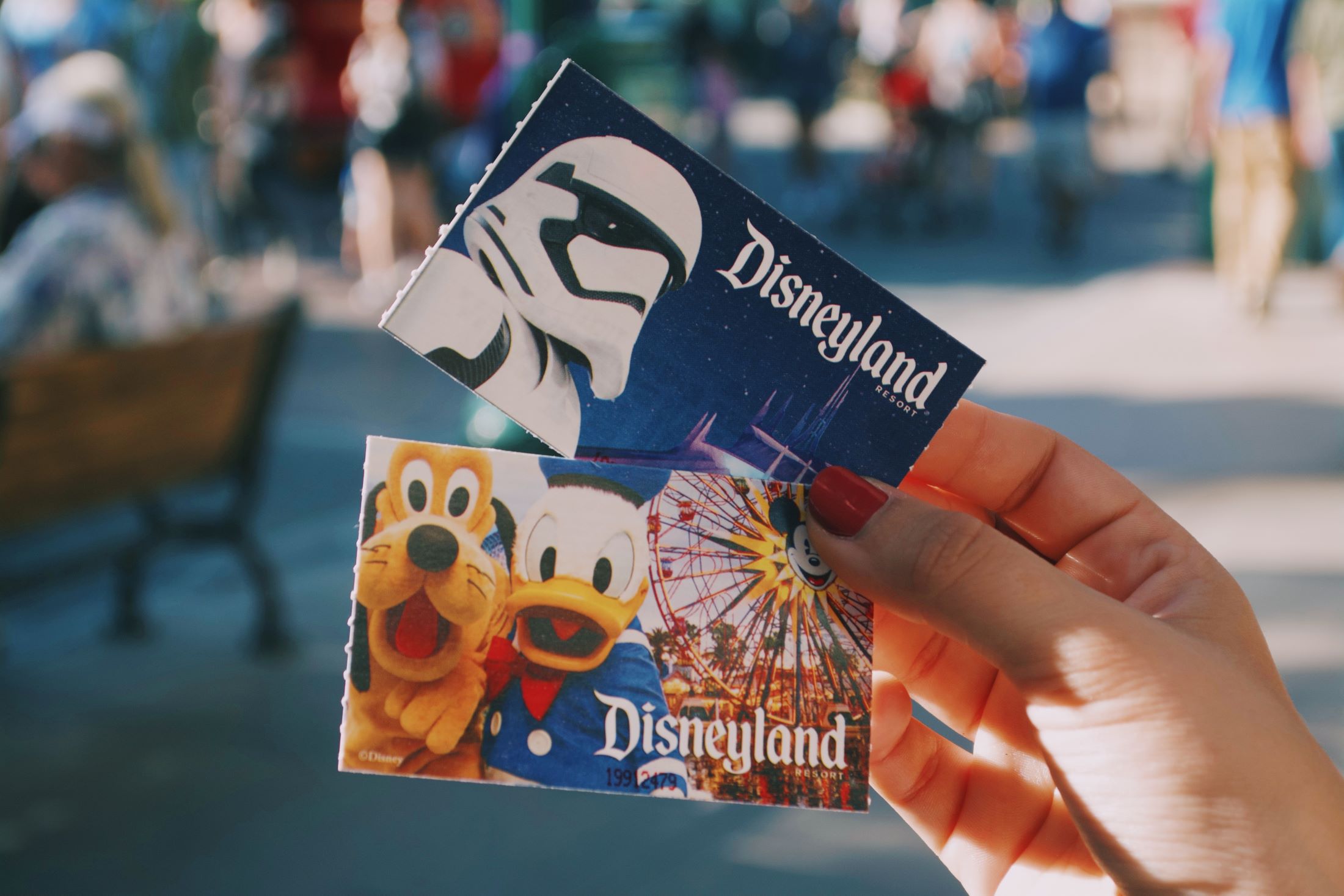 An image of someone holding Disneyland tickets.