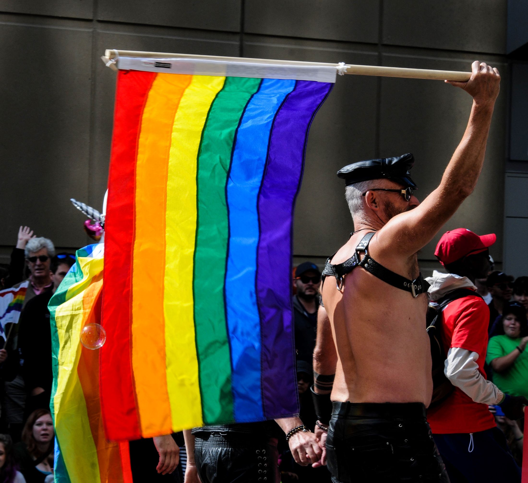 An image of people marching in a Pride parade.