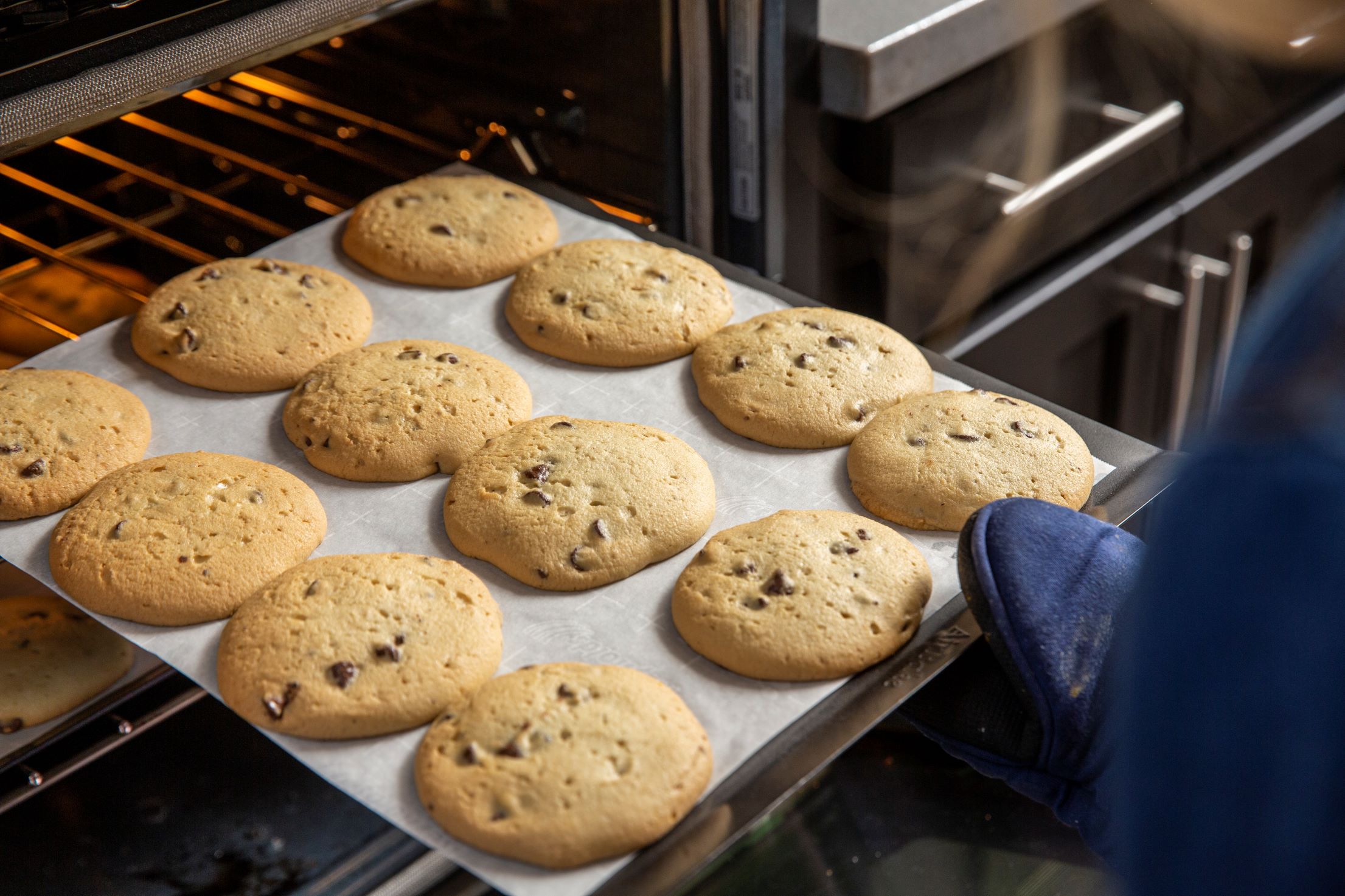 An image of a warm batch of Tiff's Treats cookies being removed from the oven.