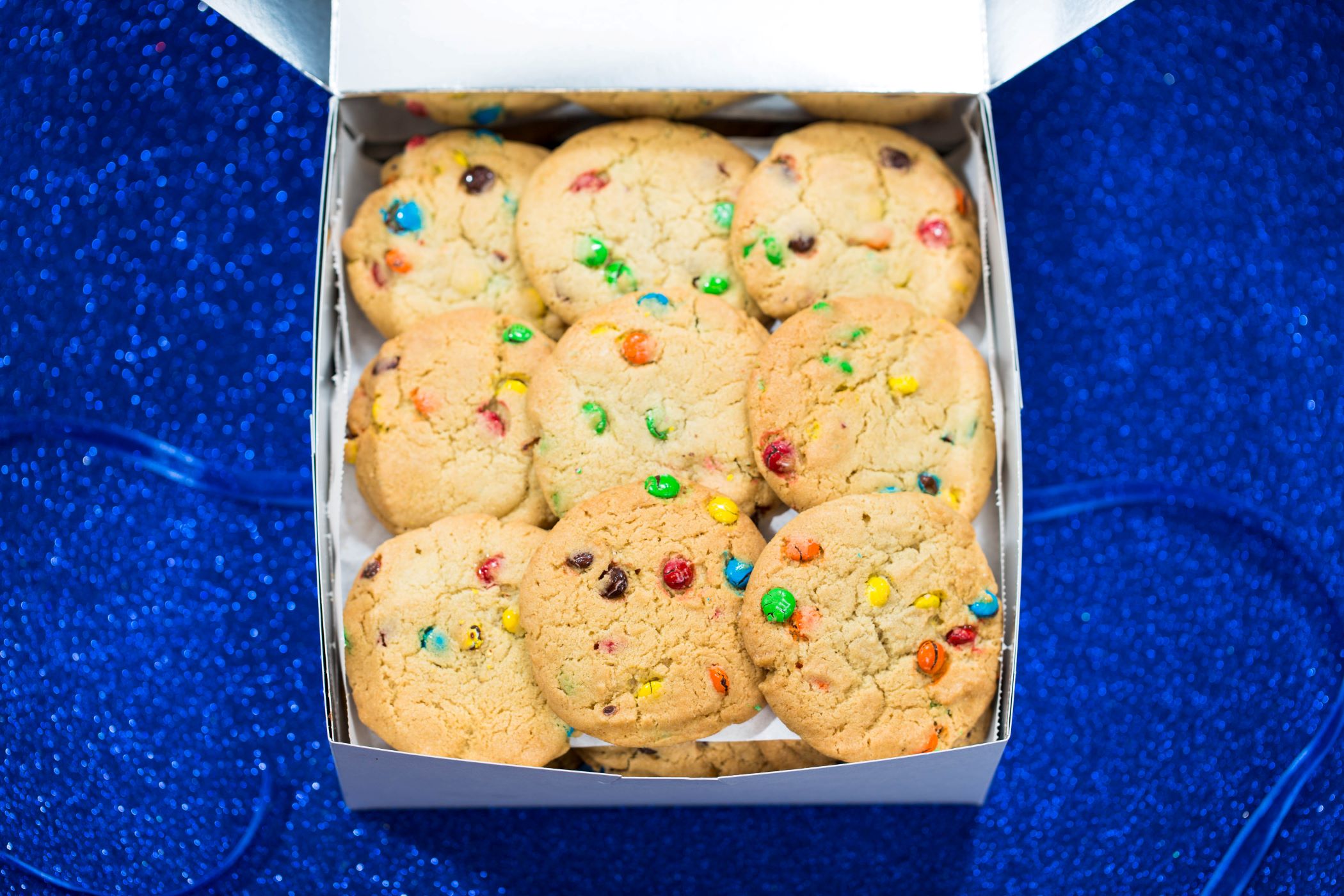 An image of a gift box of Tiff's Treats with the sugar cookie with M&Ms.