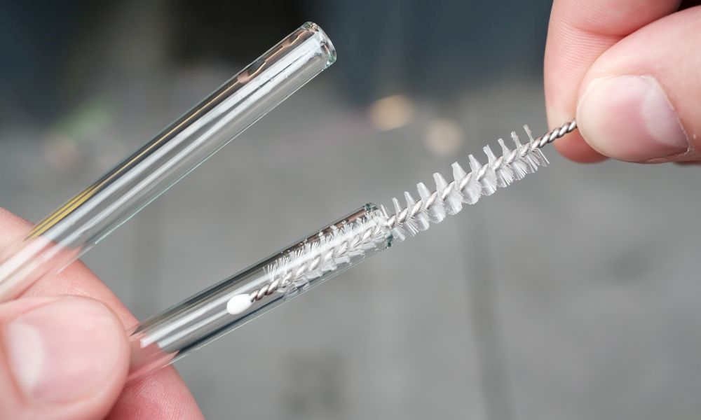 An image of reusable glass straws being cleaned. 