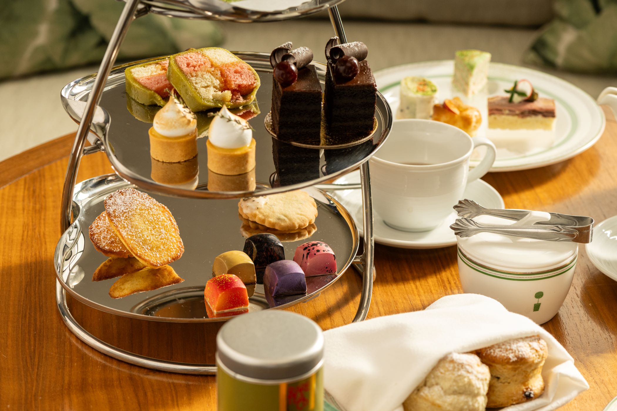 An image of the London's afternoon tea  spread, with tea, luxury chocolate, baked goods, and tea sandwiches. 