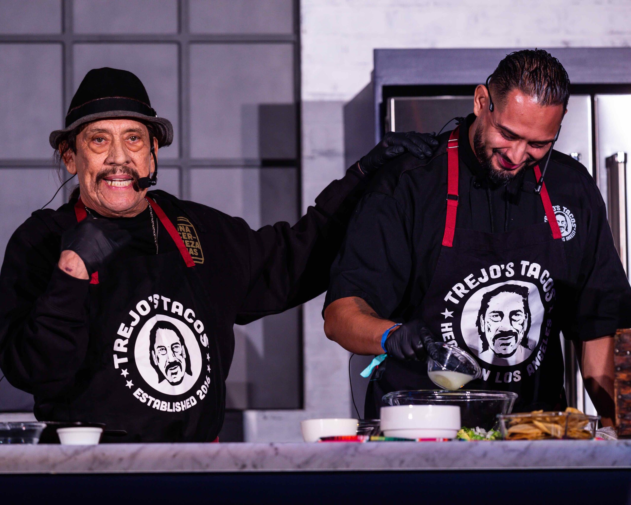 An image of Danny Trejo and his cooking partner at the LA Times Food Bowl Night Market.