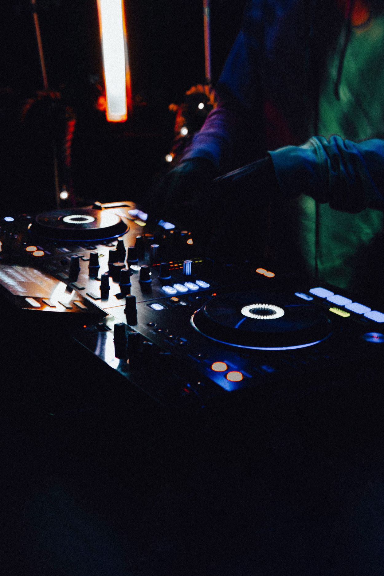 An image of a DJ on their turntables.