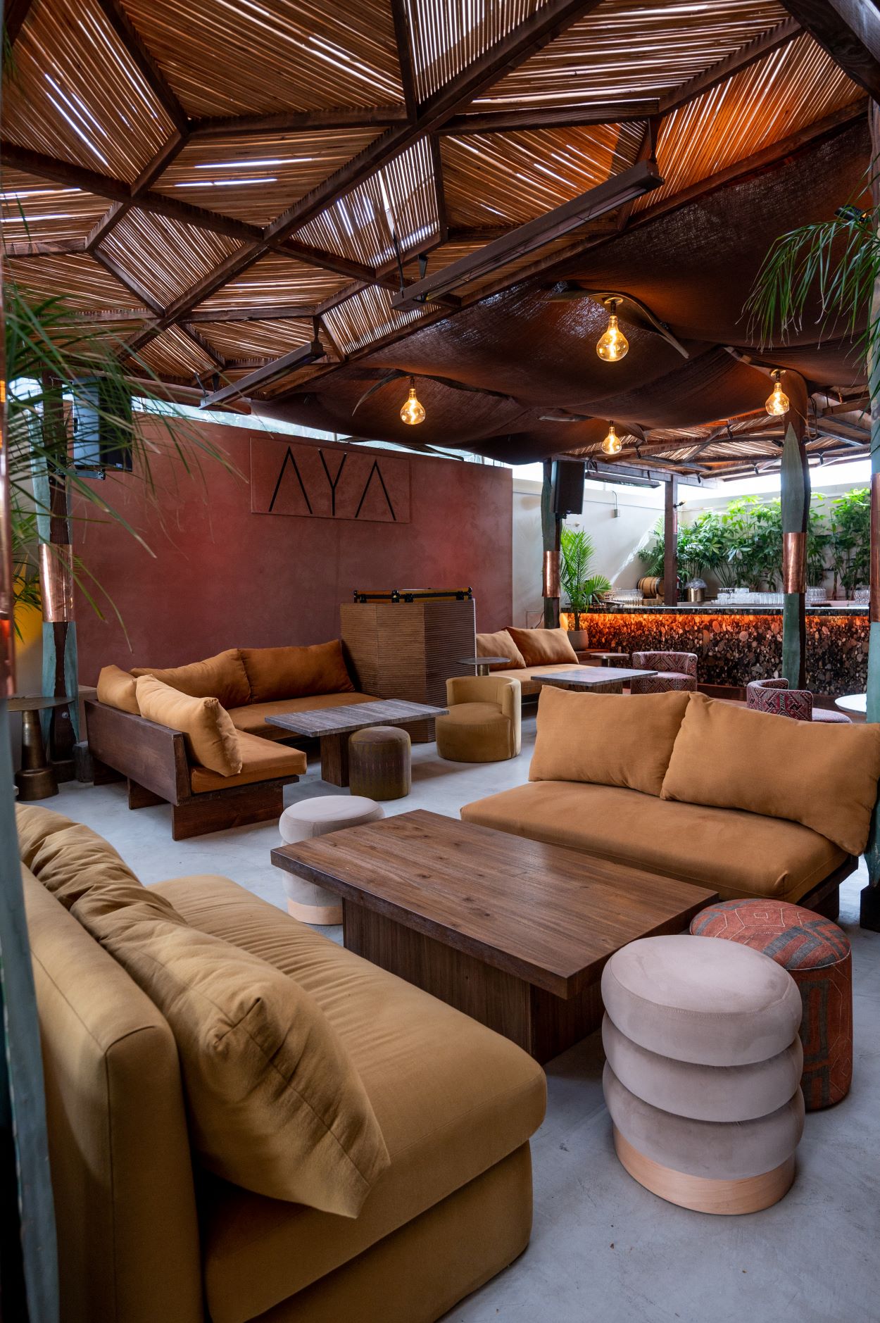 An image of AYA. With outdoor furniture, plants, and the signage.