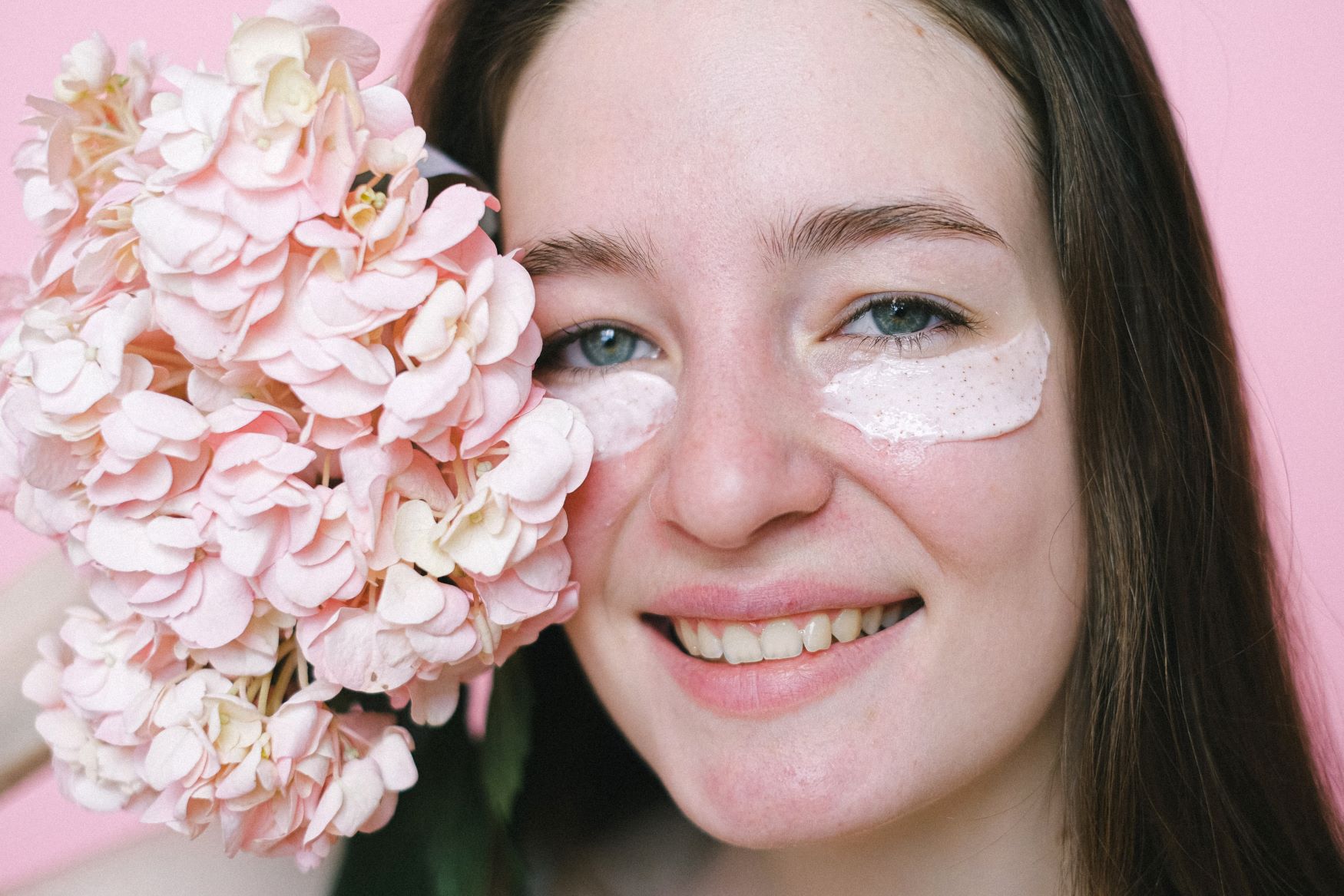 An image of a woman with eye cream on her eyes.