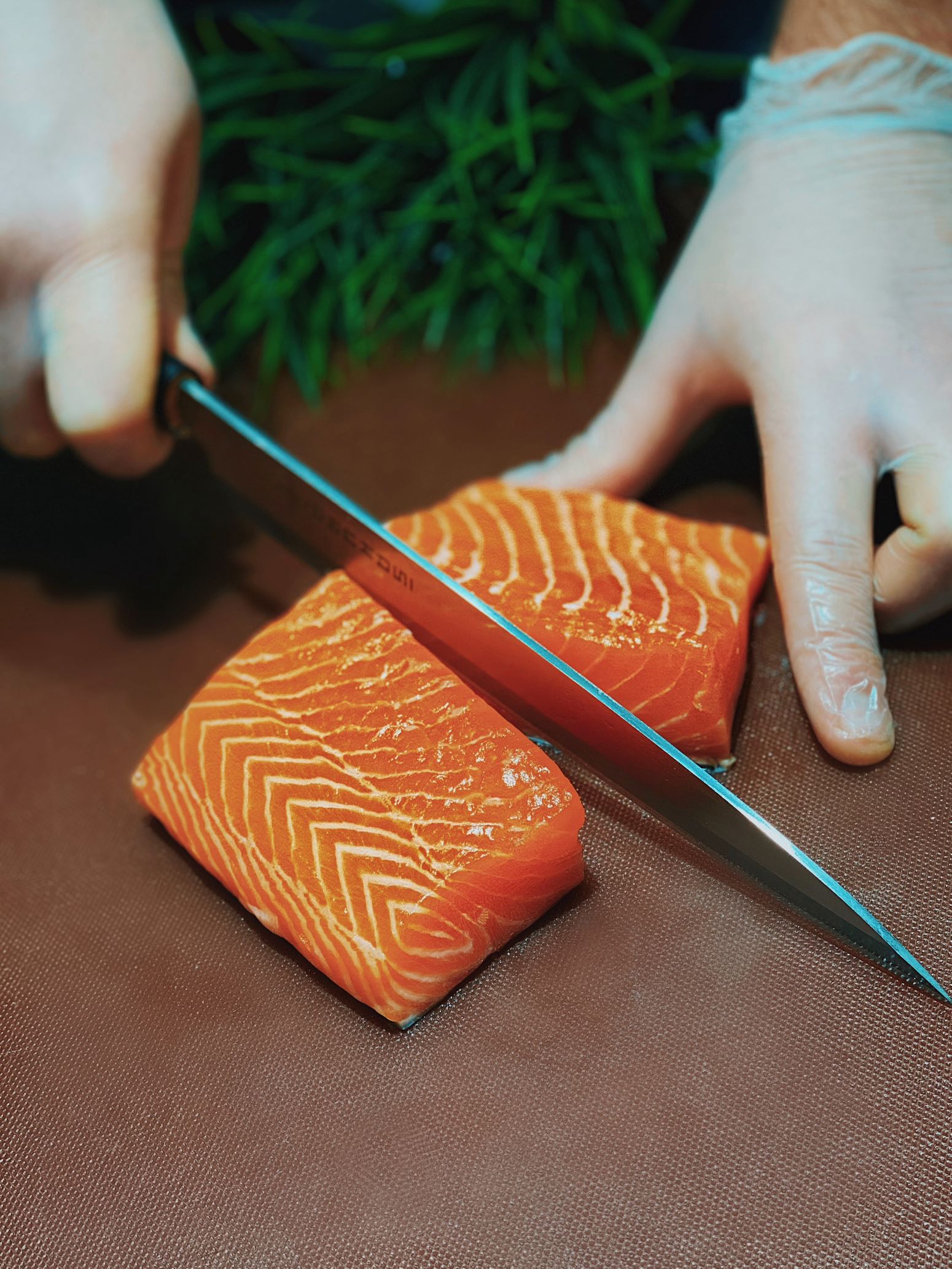 An image of someone cutting a piece of salmon.