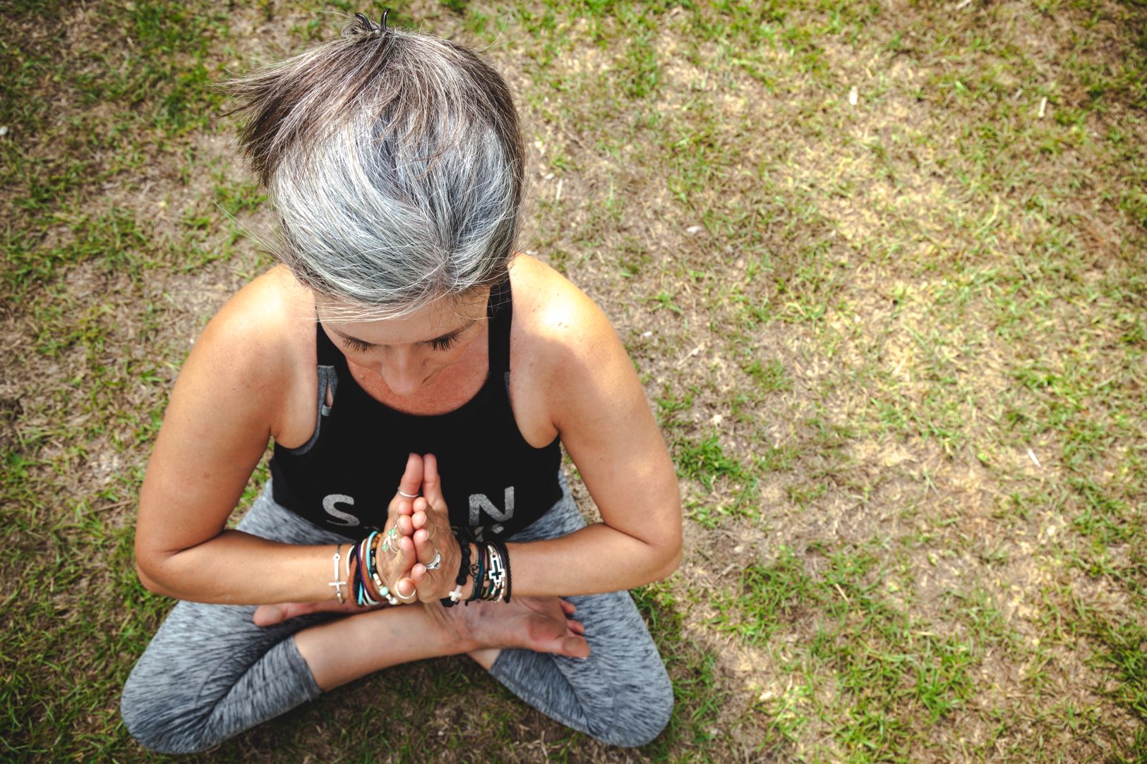 An image of a woman with gray hair in a yoga pose.