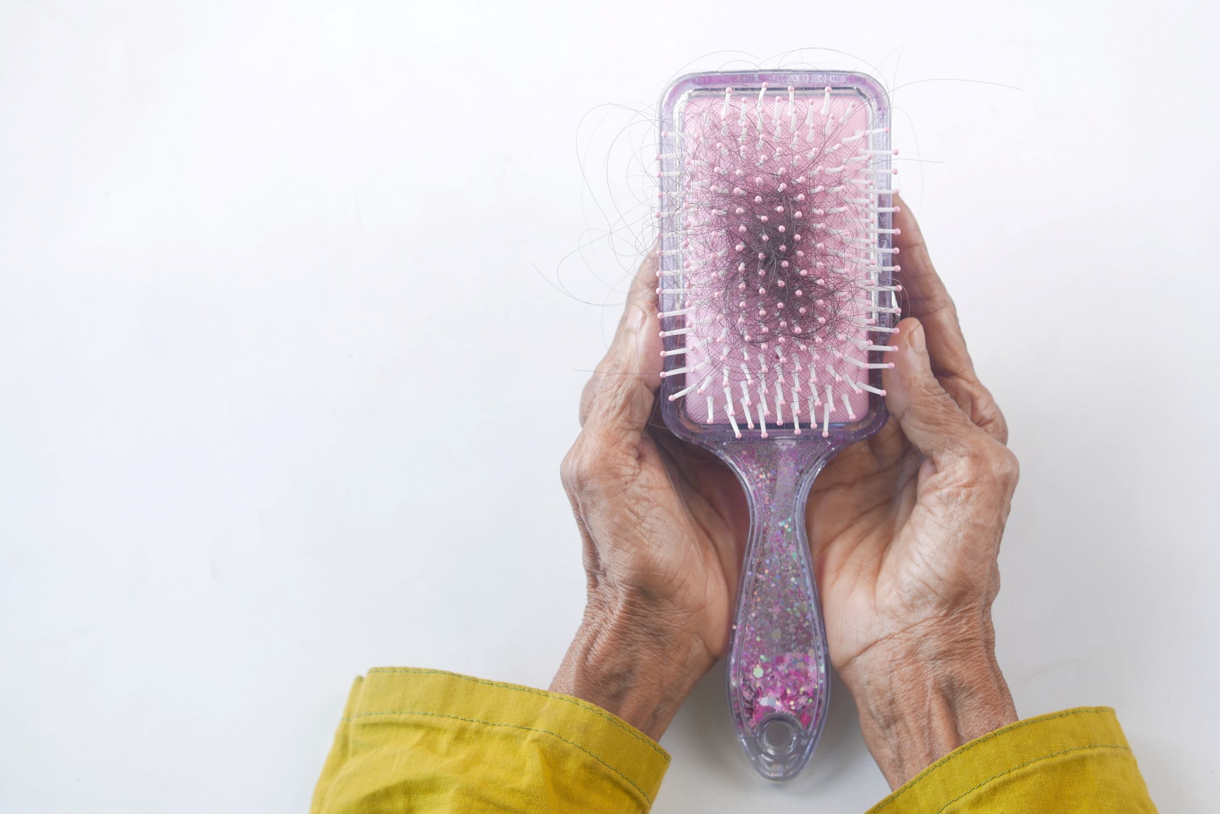 An image of a hair brush with hair in it.