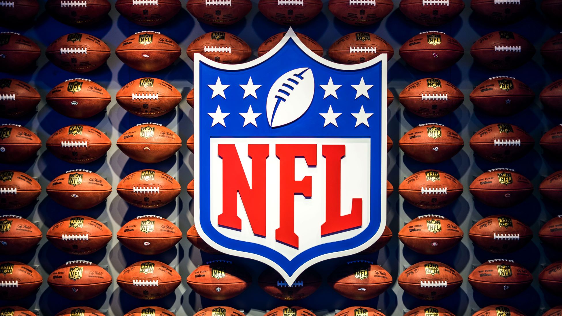 An image of the NFL logo surrounded by NFL footballs.