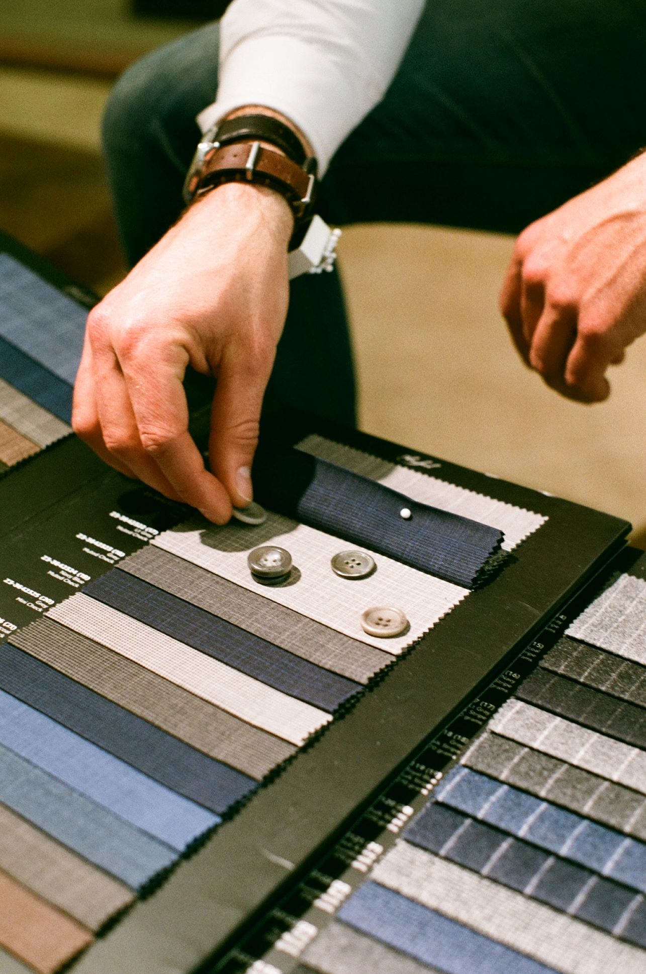An image of someone choosing a color for their tuxedo from color swatches. 