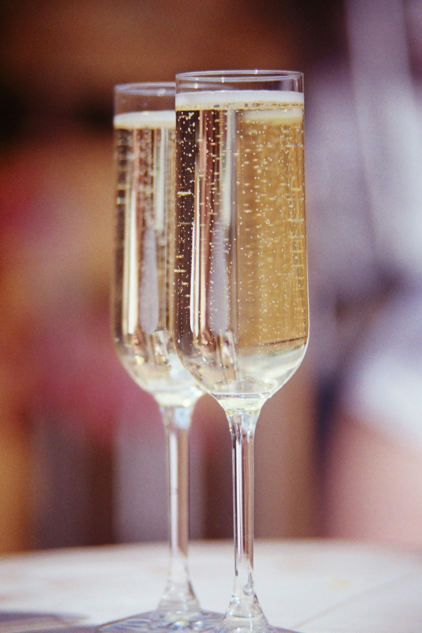 An image of 2 champagne flutes with champagne.