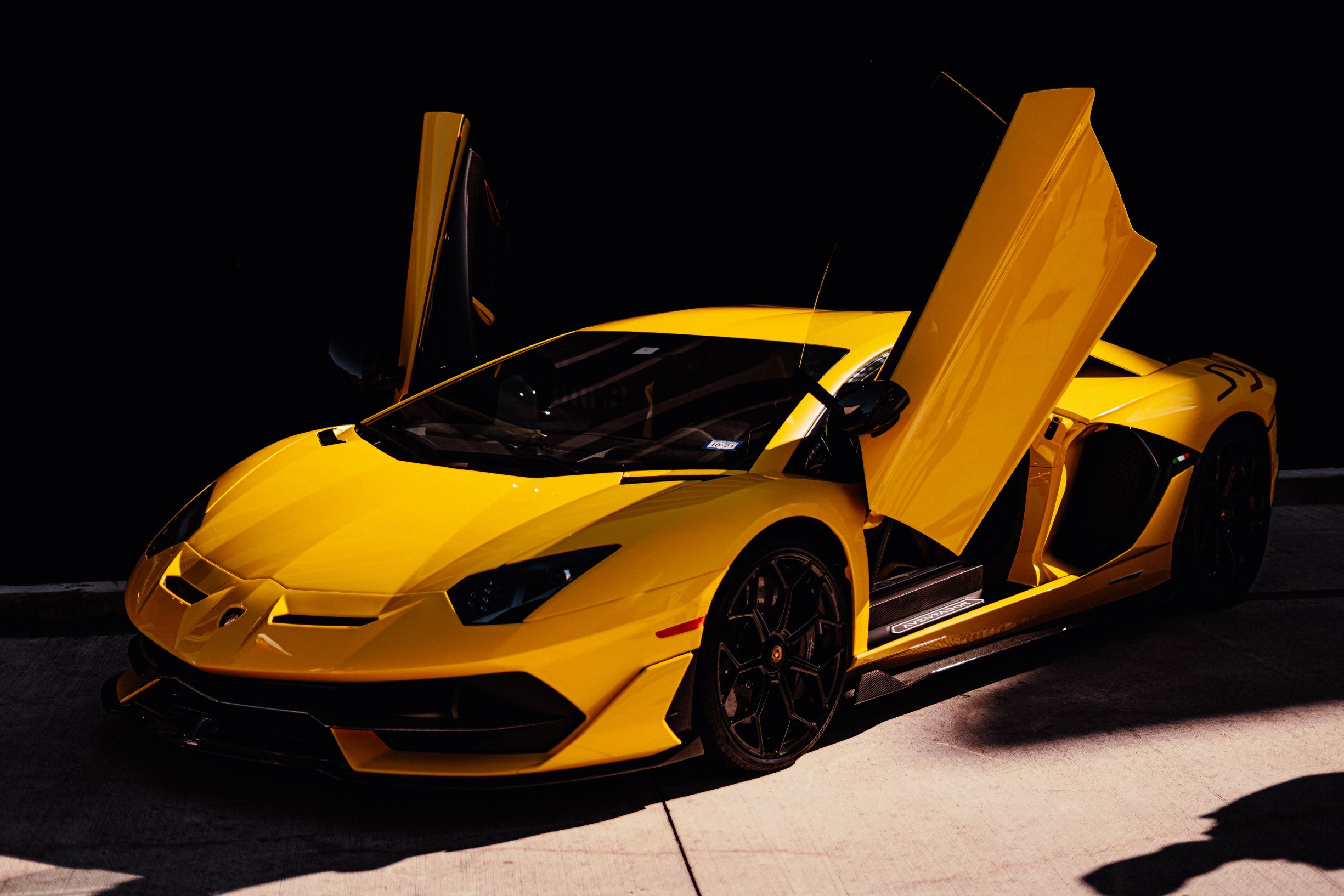 An image of a yellow supercar with its doors up.