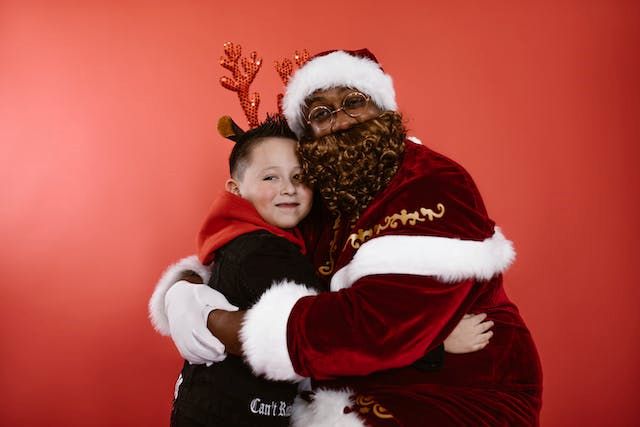 An image of a boy taking pictures with Santa.