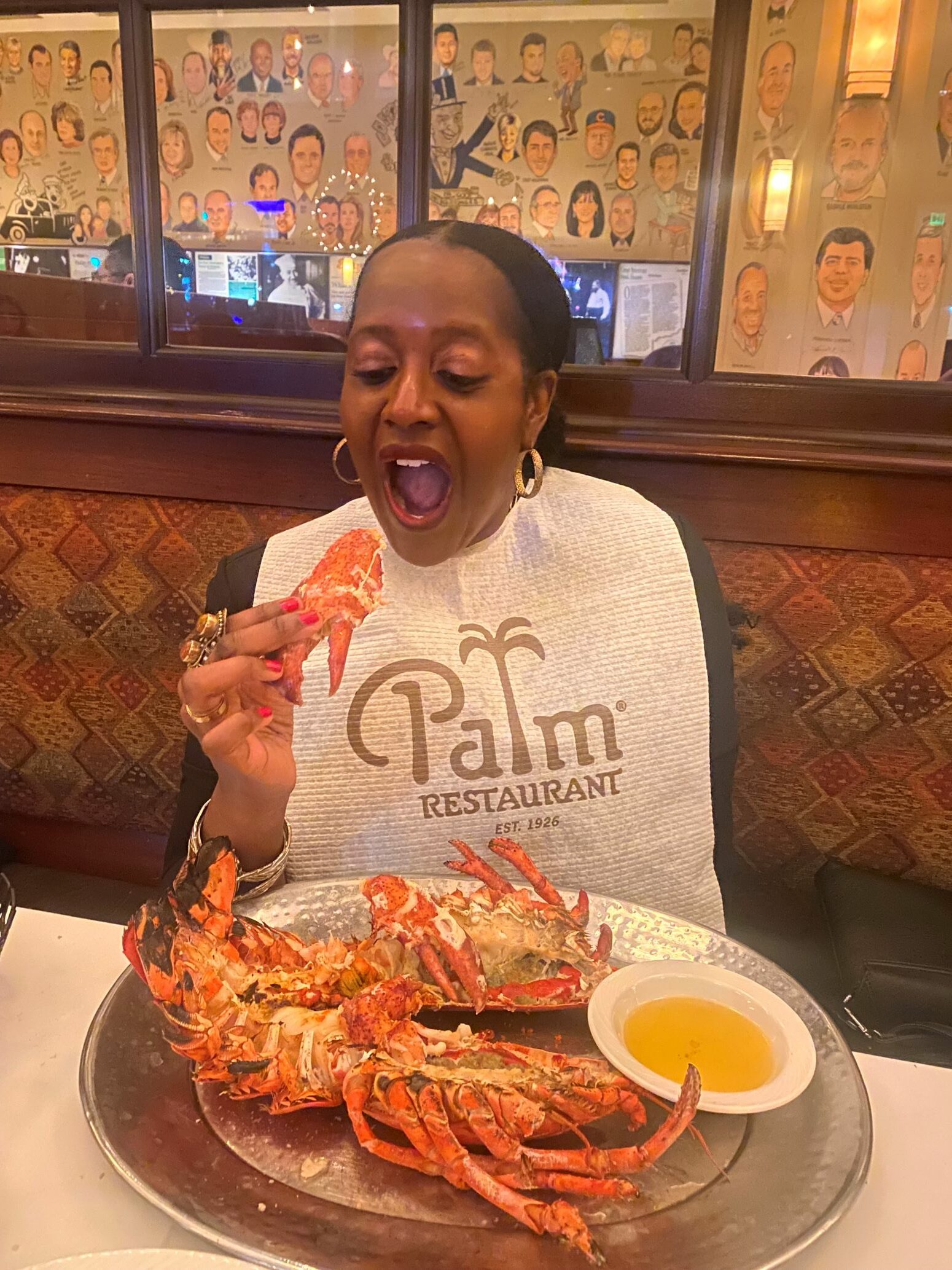 An image of woman eating a jumbo Novia Scotia lobster while wearing a bib.