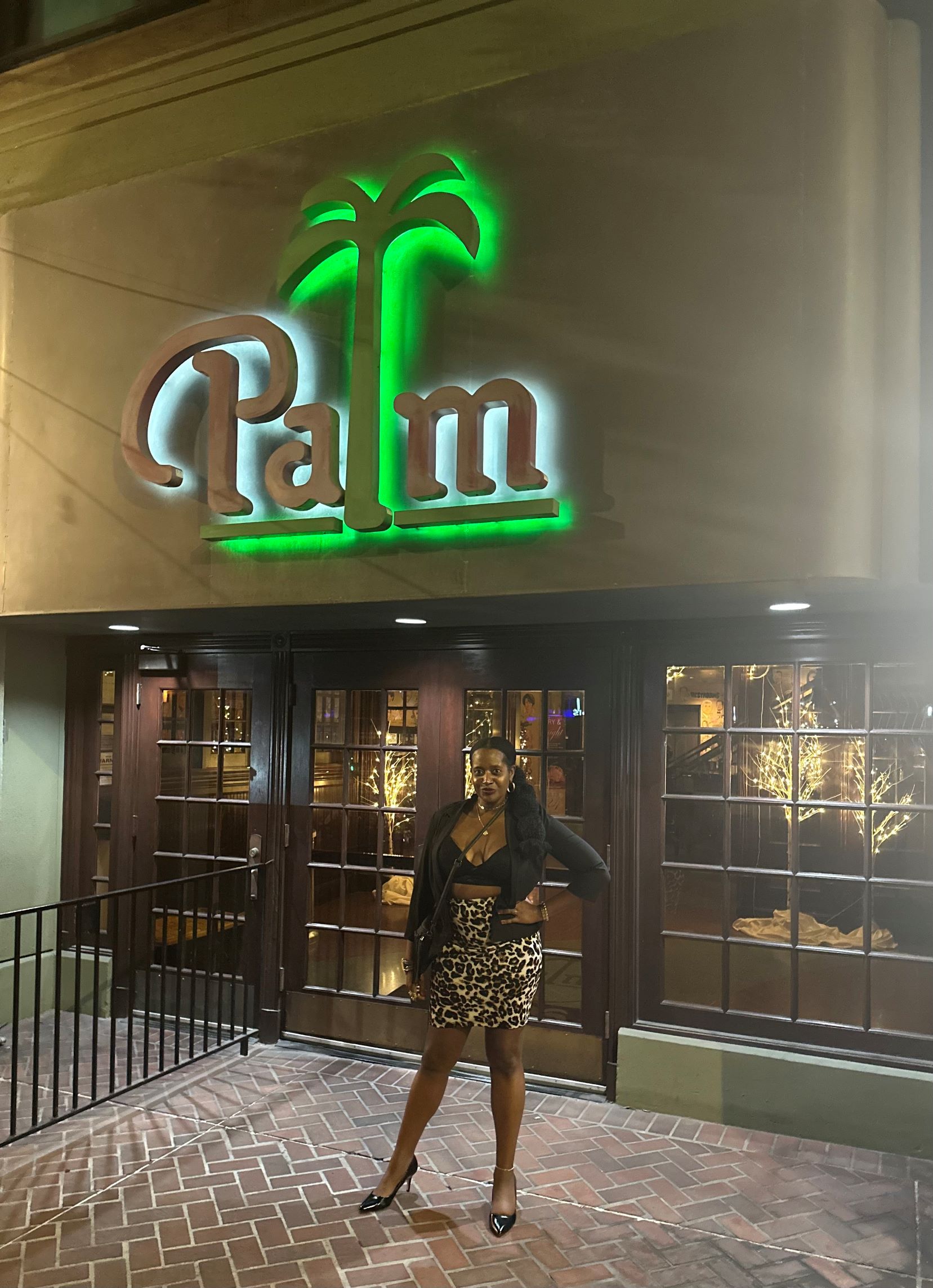 An image of a woman standing outside The Palm Los Angeles.