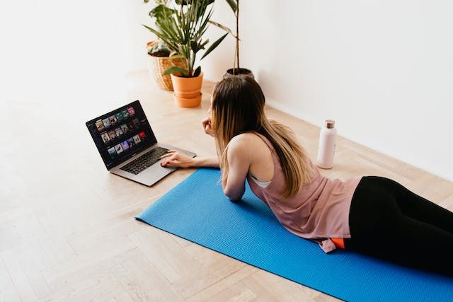 An image of a woman on a yoga mat reading about the 28 day Wall Pilates challenge.