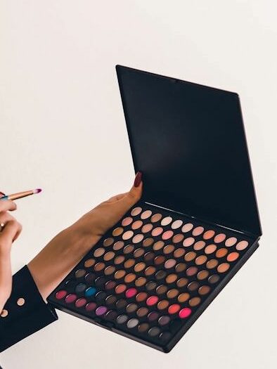 An image of someone holding a makeup palette.