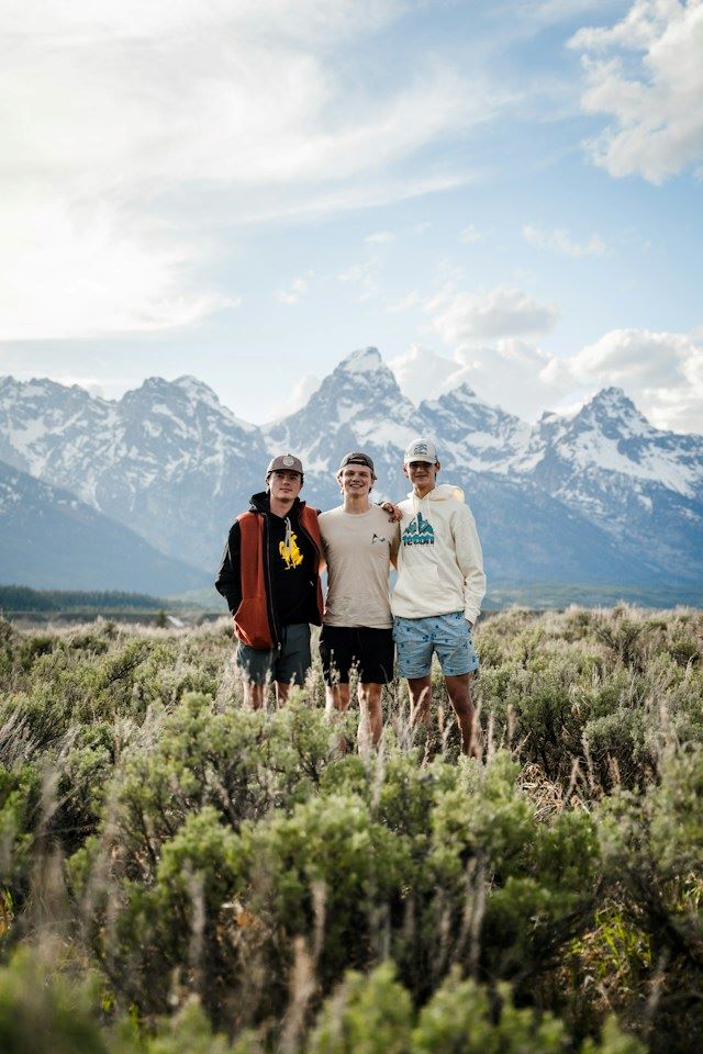 An image of three men with mountains in the background.
