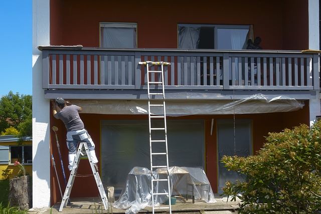 An image of a professional painter painting the exterior of a house. 