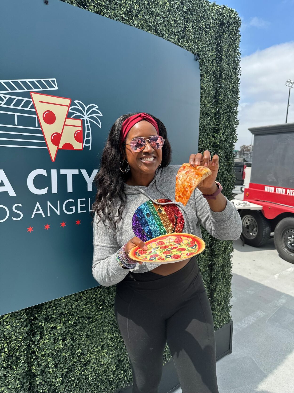 An image of lifestyle blogger Ariel holding a slice of pizza for Pizza City Fest.