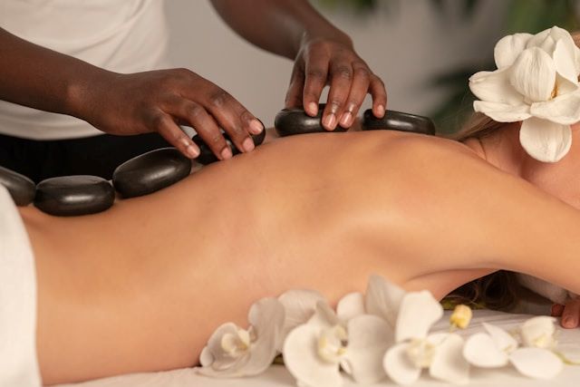 An image of a woman having a hot stone massage treatment.
