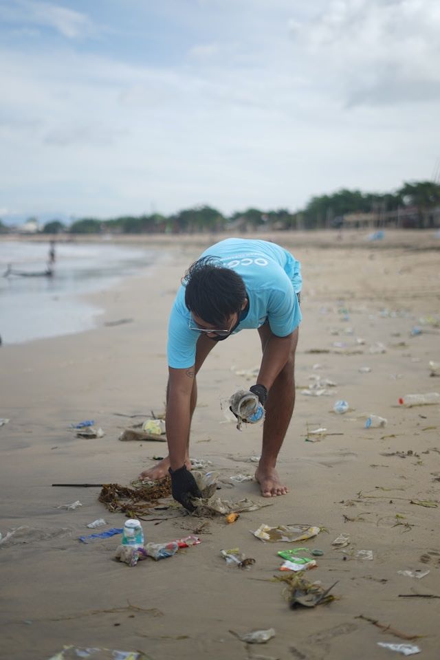 An image of an influencer cleaning up a beach.