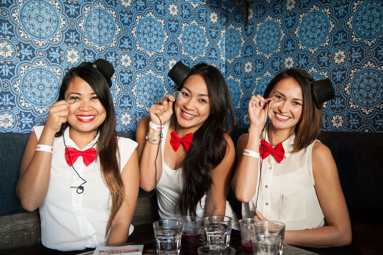 An image of three women dressed like Monopoly players with monocles in their eyes. 