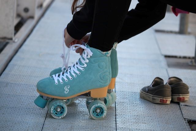 An image of someone lacing up roller skates.