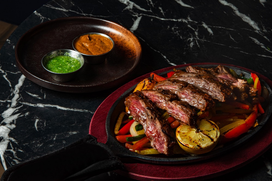 An image of the 16 oz. Ribeye Steak with a Chimichurri Macha Sauce, topped with Lemon Roasted Sweet Peppers from Agent's Only.