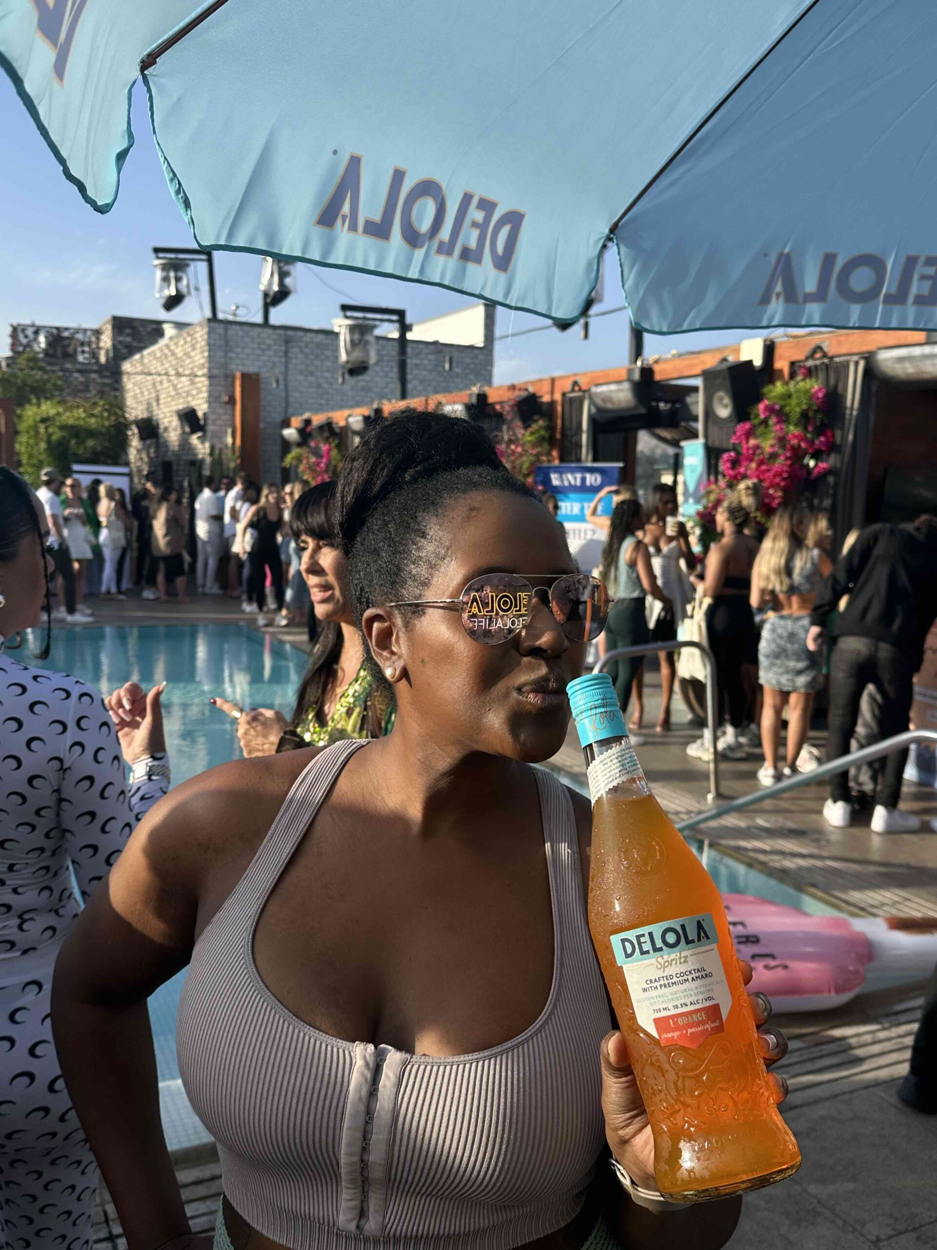 An image of lifestyle blogger Ariel holding a bottle of Jennifer Lopez's Delola low-calorie low-alcohol spritz line.