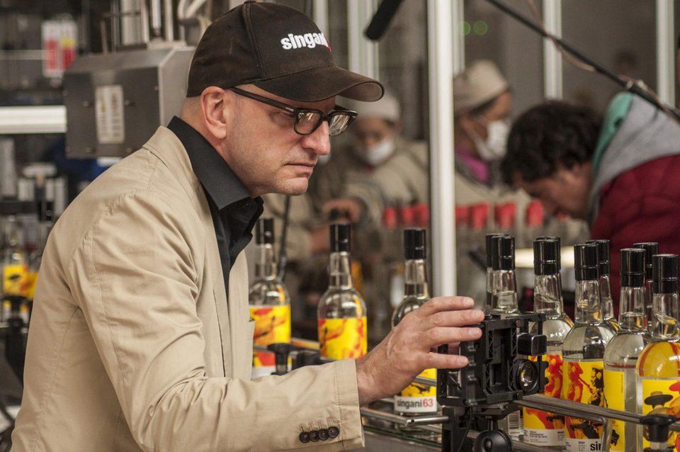 An image of director Steven Soderbergh inspecting his Singani 63 bottles perfectly served neat or as a base for on the rocks cocktails.