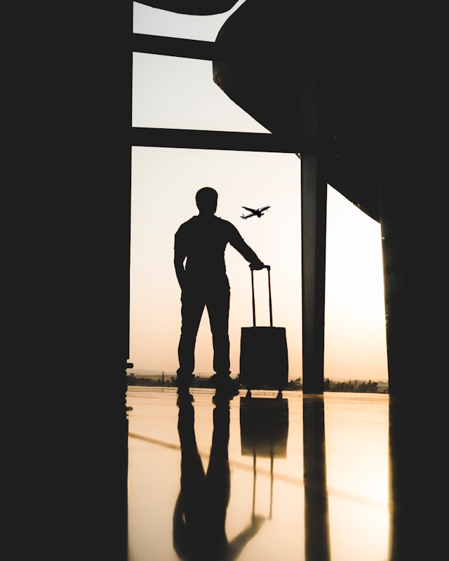 An image of a man in an airport with his suitcase.