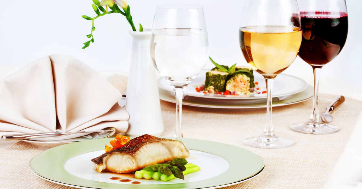 An image of a meal of fish and wines.