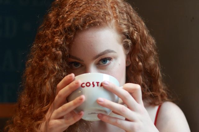 An image of a woman drinking a cup of one of the best thc drinks.