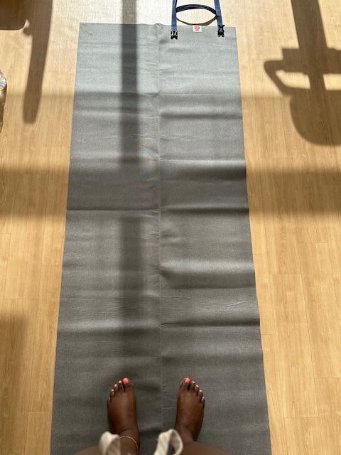An image of a pair of feet standing on the Yoga travel yoga mat.