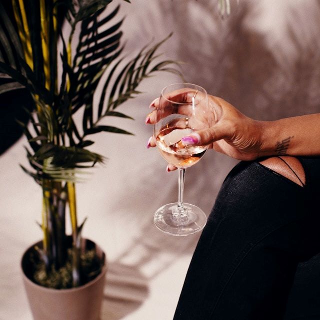 An image of a person holding a glass of wine.