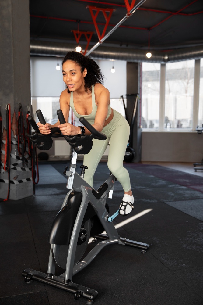 An image of a woman on an indoor cycling bike.